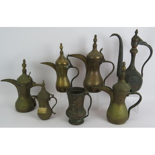 147 - Five brass Eastern Dallah coffee pots of varying size, an engraved Indo-Persian coffee pot and a hea... 