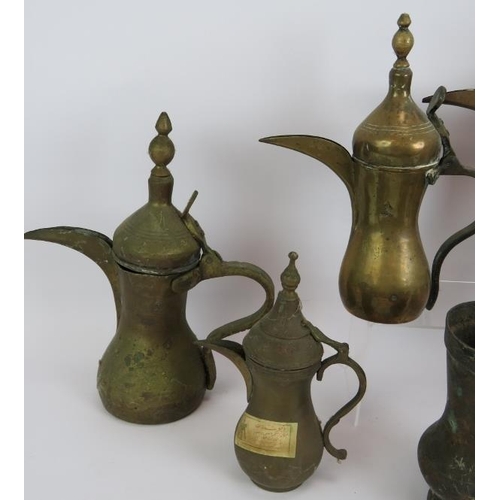 147 - Five brass Eastern Dallah coffee pots of varying size, an engraved Indo-Persian coffee pot and a hea... 