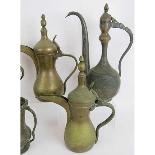 147 - Five brass Eastern Dallah coffee pots of varying size, an engraved Indo-Persian coffee pot and a hea... 