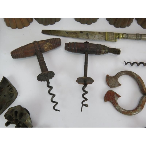 149 - Six antique copper jelly moulds, three antique corkscrews, a brass crimper, biscuit cutters, Eastern... 