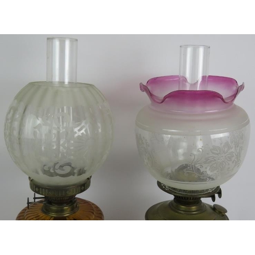 161 - Two antique oil lamps, one with amber reservoir and etched globe shade, the other with brass reservo... 