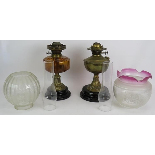 161 - Two antique oil lamps, one with amber reservoir and etched globe shade, the other with brass reservo... 