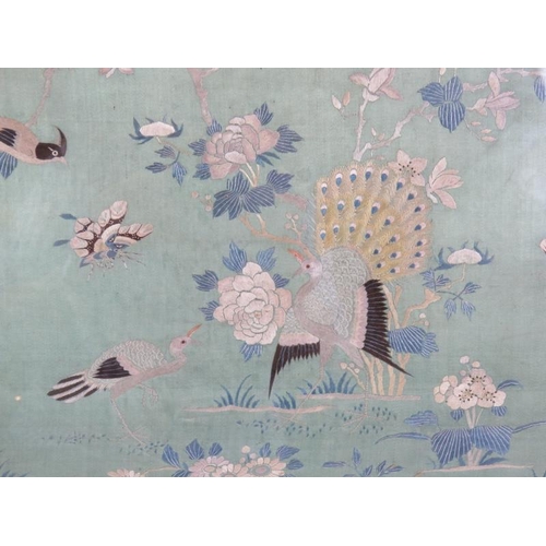 224 - A framed Chinese silkwork panel depicting peacocks, birds and butterflies on a turquoise ground. 47c... 