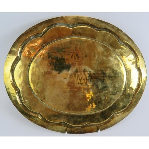 25 - An antique hand beaten Indo-Persian brass dish of oval form with raised rim decorated with birds aro... 