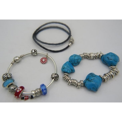 399 - A collection of three Pandora bracelets to include a charm bracelet and a howlet & white metal brace... 