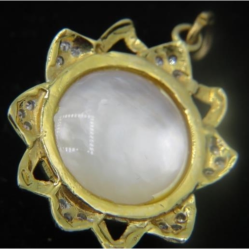 436 - An unmarked yellow metal star shaped diamond and mabe pearl pendant. The centre mabe pearl surrounde... 