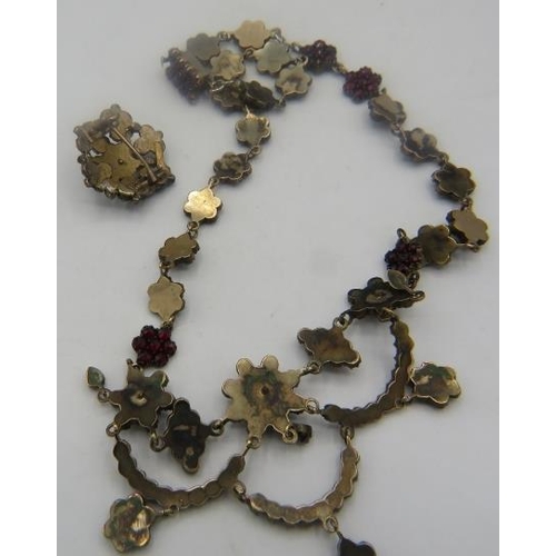 453 - A Czechoslovakian yellow metal garnet necklace made up of clusters of garnets with larger group at t... 