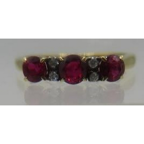 462 - An unmarked yellow metal ring set with three good coloured rubies & four small diamonds. Centre ruby... 