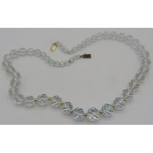 468 - A white topaz graduated and faceted cut necklace with yellow metal spacers on a 14ct yellow gold cla... 