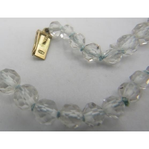 468 - A white topaz graduated and faceted cut necklace with yellow metal spacers on a 14ct yellow gold cla... 