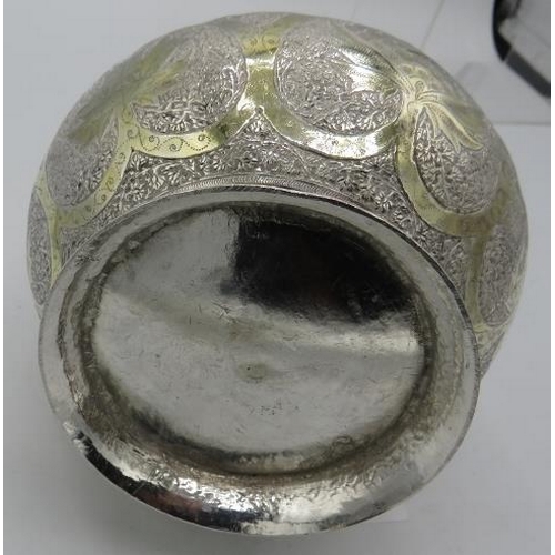 484 - A white metal Middle Eastern flask engraved with panels of leaves. Approx 11