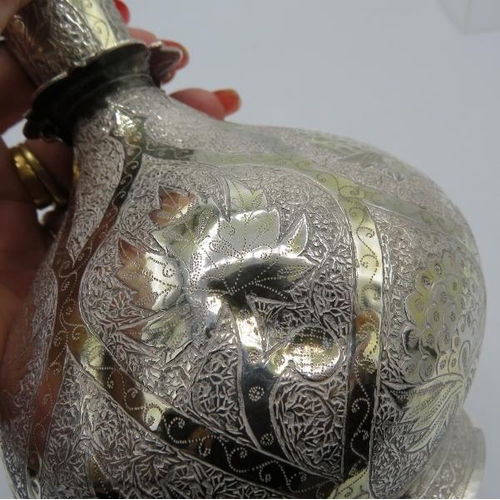 484 - A white metal Middle Eastern flask engraved with panels of leaves. Approx 11