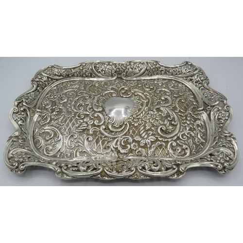 487 - A silver dressing table tray, heavily embossed scrolls & foliate design, Birmingham 1899. Approx 12