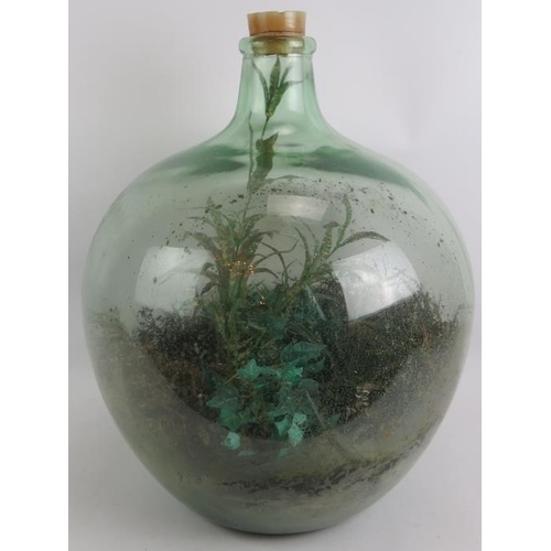 65 - A large green glass carboy planted as a terrarium with a mix of real and artificial plants. Height 5... 