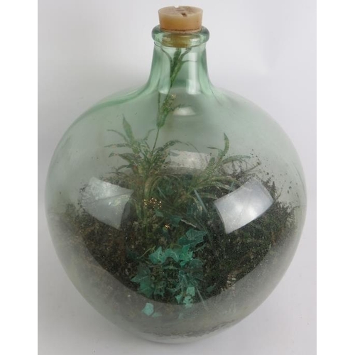 65 - A large green glass carboy planted as a terrarium with a mix of real and artificial plants. Height 5... 