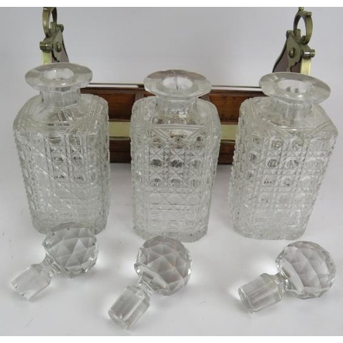 66 - An Edwardian oak 3 decanter tantalus with locking mechanism and nickel mounts. Each decanter hobnail... 