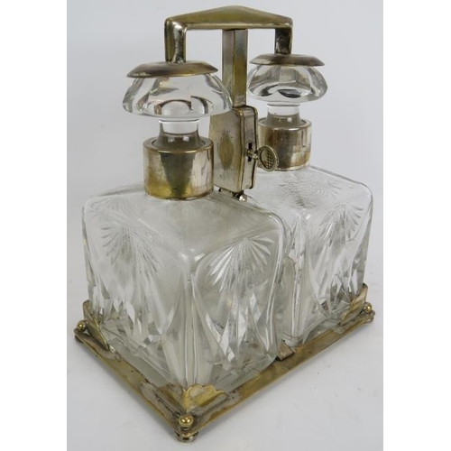 67 - A silver plated two decanter tantalus by WMF, c1930. Plated stand with key operated sprung mechanism... 