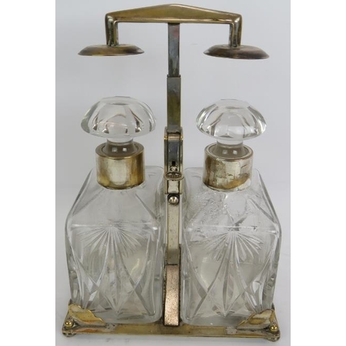 67 - A silver plated two decanter tantalus by WMF, c1930. Plated stand with key operated sprung mechanism... 