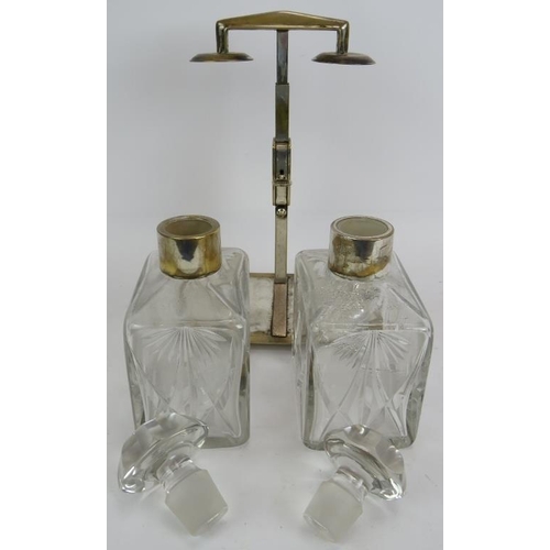 67 - A silver plated two decanter tantalus by WMF, c1930. Plated stand with key operated sprung mechanism... 