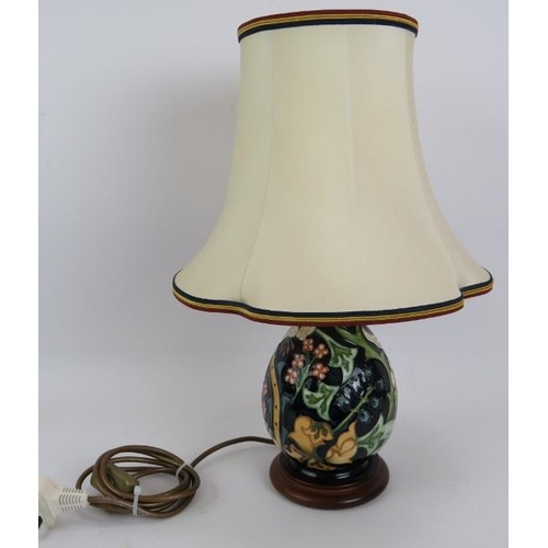 94 - A Moorcroft pottery lamp of balluster form, on a turned wood base. Base height 22cm. Overall height ... 