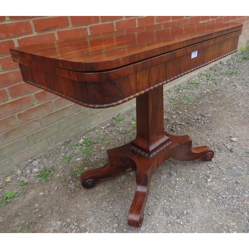 855 - A William IV rosewood turnover card table with inset green baize, featuring gadrooned edging, on a t... 