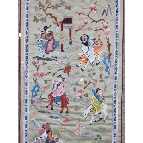 225 - A framed Chinese silkwork panel depicting various figures riding various beasts within an ornate sil... 