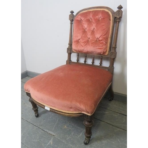 879 - A turn of the century mahogany nursing chair with reeded uprights and finials, upholstered in button... 