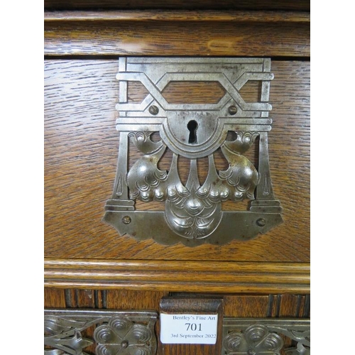 701 - An Arts & Crafts medium oak cabinet featuring ornate pierced steel escutcheons, drop ring handles an... 