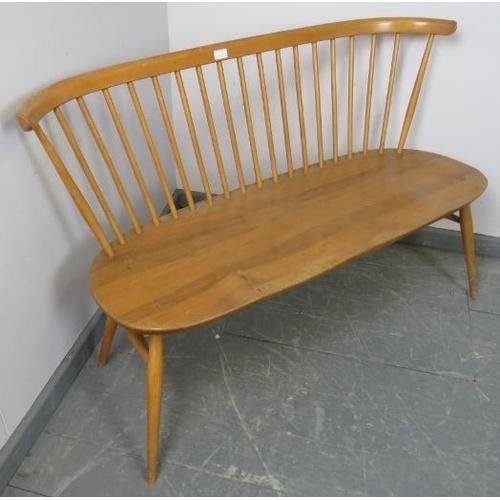 711 - A mid-century blond elm Windsor love seat by Ercol, on canted supports with an ‘H’ stretcher. 
Condi... 