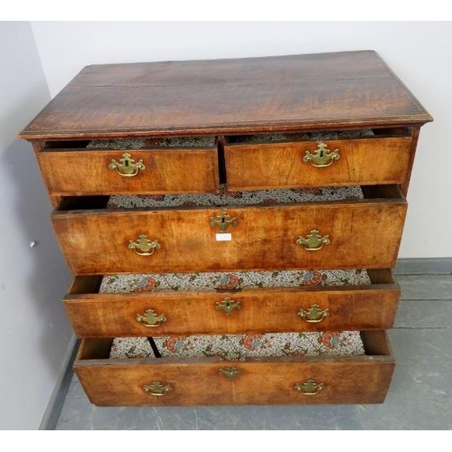 715 - An early 18th century oak and burr walnut chest of two short over three long graduated drawers with ... 