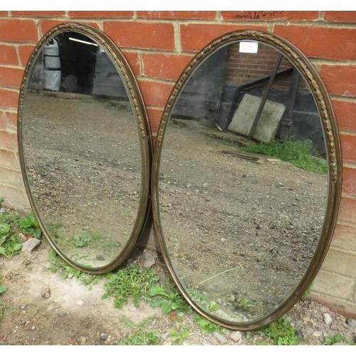 716 - A pair of 19th century French oval wall mirrors in bronze frames with cast tulip decoration to both ... 