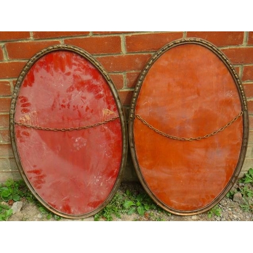 716 - A pair of 19th century French oval wall mirrors in bronze frames with cast tulip decoration to both ... 