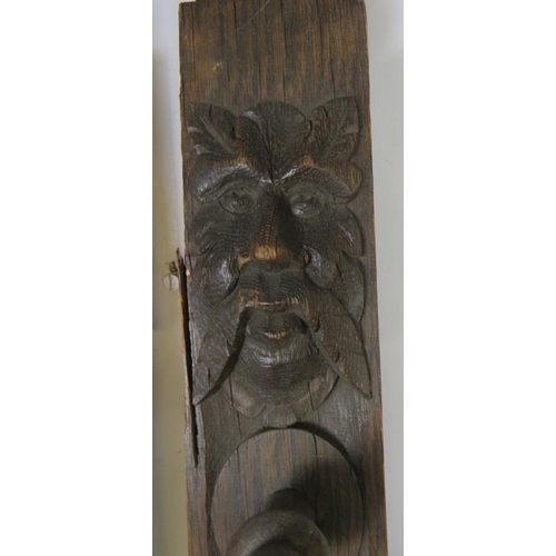 727 - A pair of 19th century oak uprights, each carved with a green man mask and depictions of fruit and f... 