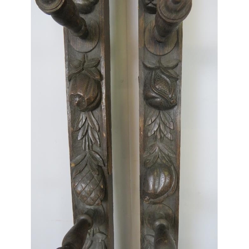 727 - A pair of 19th century oak uprights, each carved with a green man mask and depictions of fruit and f... 