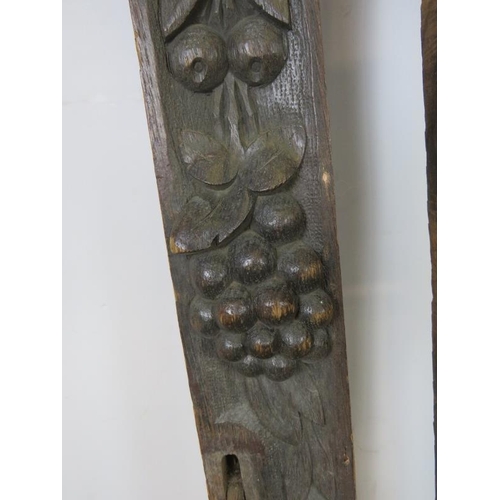 727 - A pair of 19th century oak uprights, each carved with a green man mask and depictions of fruit and f... 