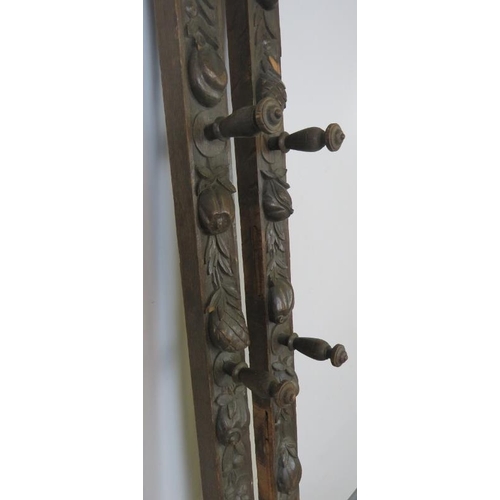 727 - A pair of 19th century oak uprights, each carved with a green man mask and depictions of fruit and f... 