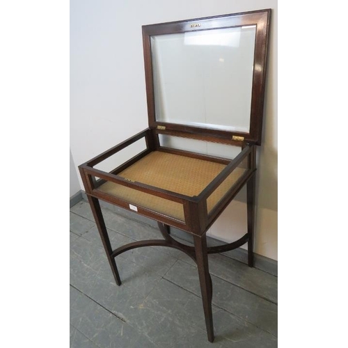 730 - An Edwardian mahogany bijouterie table, the rising lid with inset bevelled glass, on tapering square... 