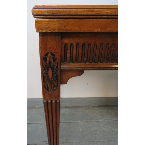 740 - An Edwardian mahogany turnover card table, with carved frieze, on tapering square reeded supports wi... 