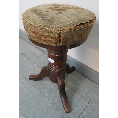 743 - A Victorian mahogany height adjustable music stool, retaining the original tapestry seat and horseha... 