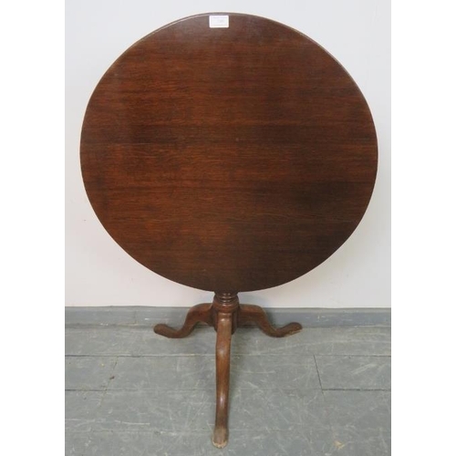 749 - A Georgian oak circular tilt top occasional table, on a tapering turned column with splayed tripod b... 