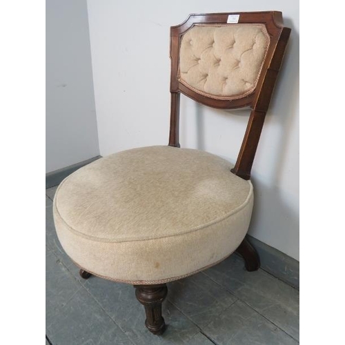 764 - A late Victorian mahogany circular bedroom chair, upholstered in beige buttoned material, on taperin... 