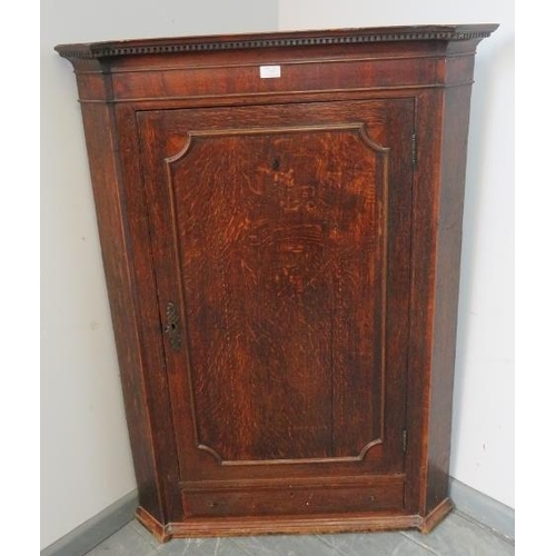 770 - A Georgian oak hanging corner cupboard, with dentil cornice, three fitted shelves and single drawer ... 