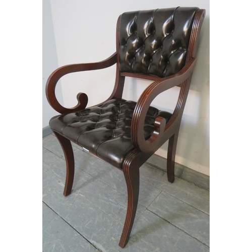 775 - A reproduction mahogany desk chair in the Regency taste, upholstered in chocolate brown buttoned lea... 