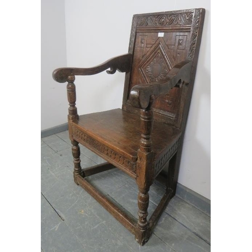 782 - A 17th century and later oak wainscot chair, with relief carved and panelled back, scrolled arms and... 