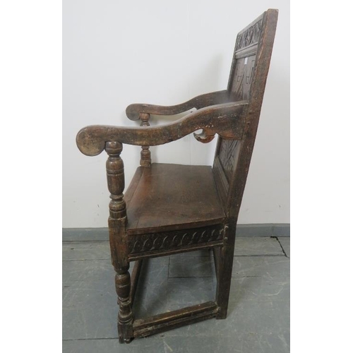 782 - A 17th century and later oak wainscot chair, with relief carved and panelled back, scrolled arms and... 