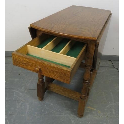 789 - A bespoke medium oak gate-leg table in an 18th century taste, with drawers to either side, on balust... 