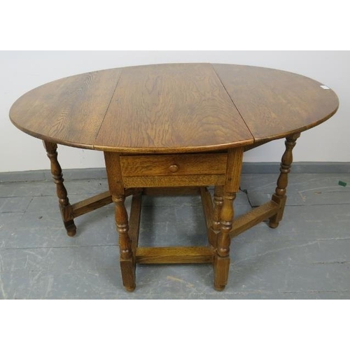 789 - A bespoke medium oak gate-leg table in an 18th century taste, with drawers to either side, on balust... 