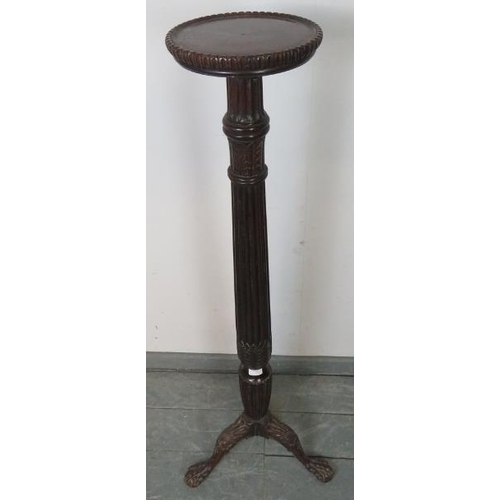 790 - A Victorian mahogany torchere with carved and fluted column, on a shell carved tripod base with claw... 