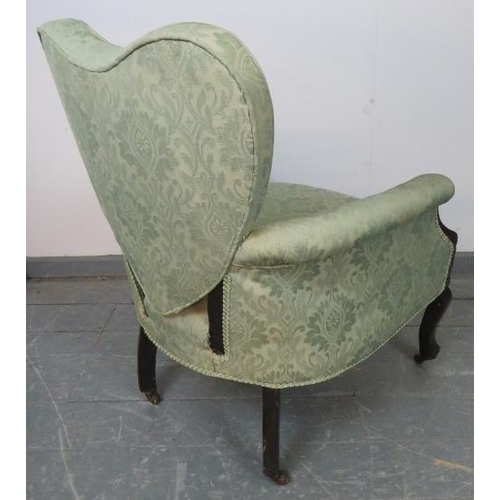 792 - A turn of the century ebonised Ladies armchair with heart shaped backrest and scrolled arms, upholst... 