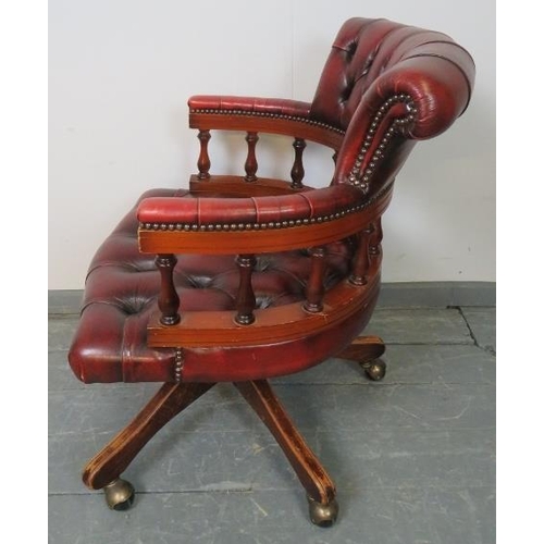 794 - A vintage mahogany Captain’s swivel and reclining desk chair, upholstered in buttoned burgundy leath... 